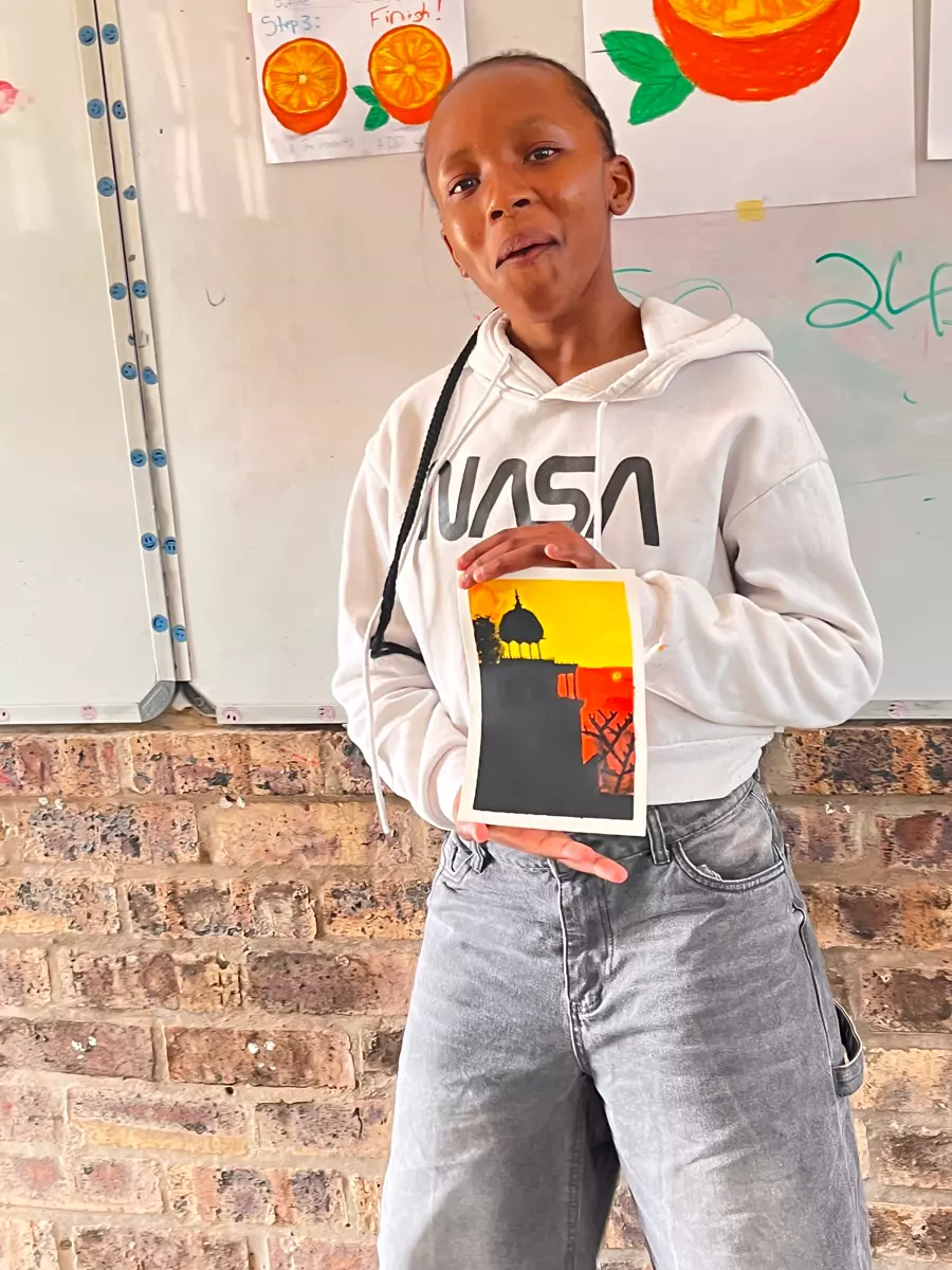 A young woman holding a painted artwork