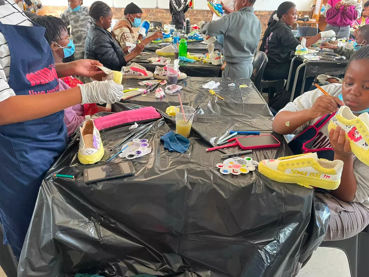 Children painting sneakers in a workshop