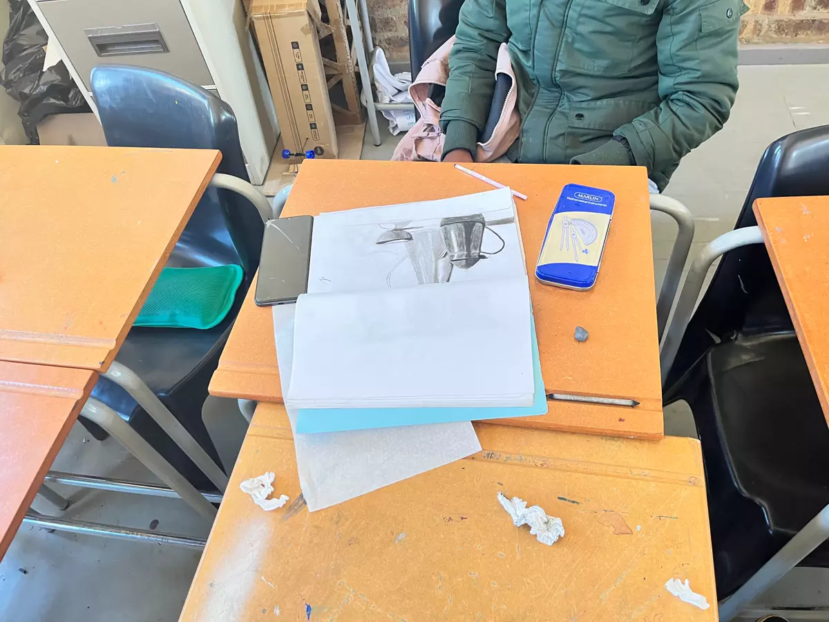 School desk with drawing pad and stationery laid out