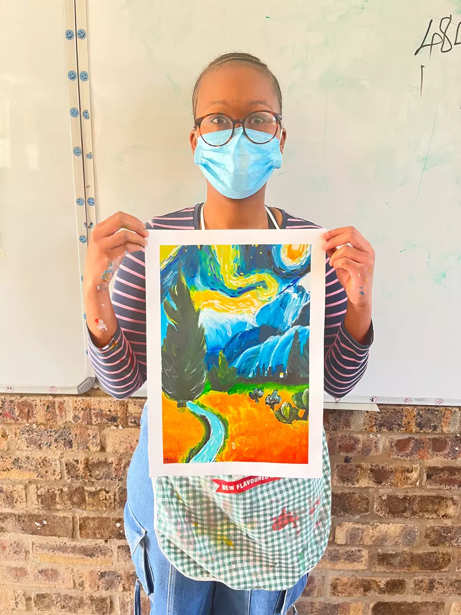 A woman holding up a painting